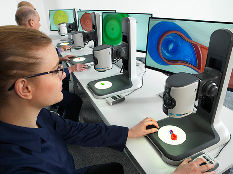 Four users in a row using EVO-Cam II digital microscope inspecting plastic samples