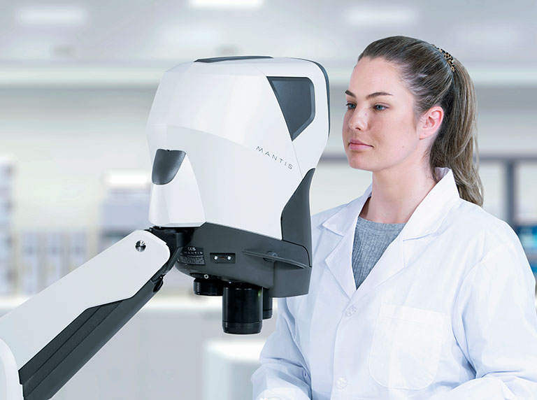 Woman in white coat looking into Mantis viewer