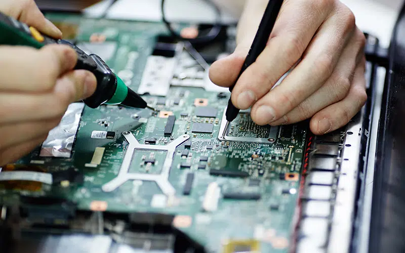 AURA-solder-PCB-AdobeStock_136939755-800×500 Primo piano delle mani di una persona che utilizza un saldatore su un circuito stampato (PCB).